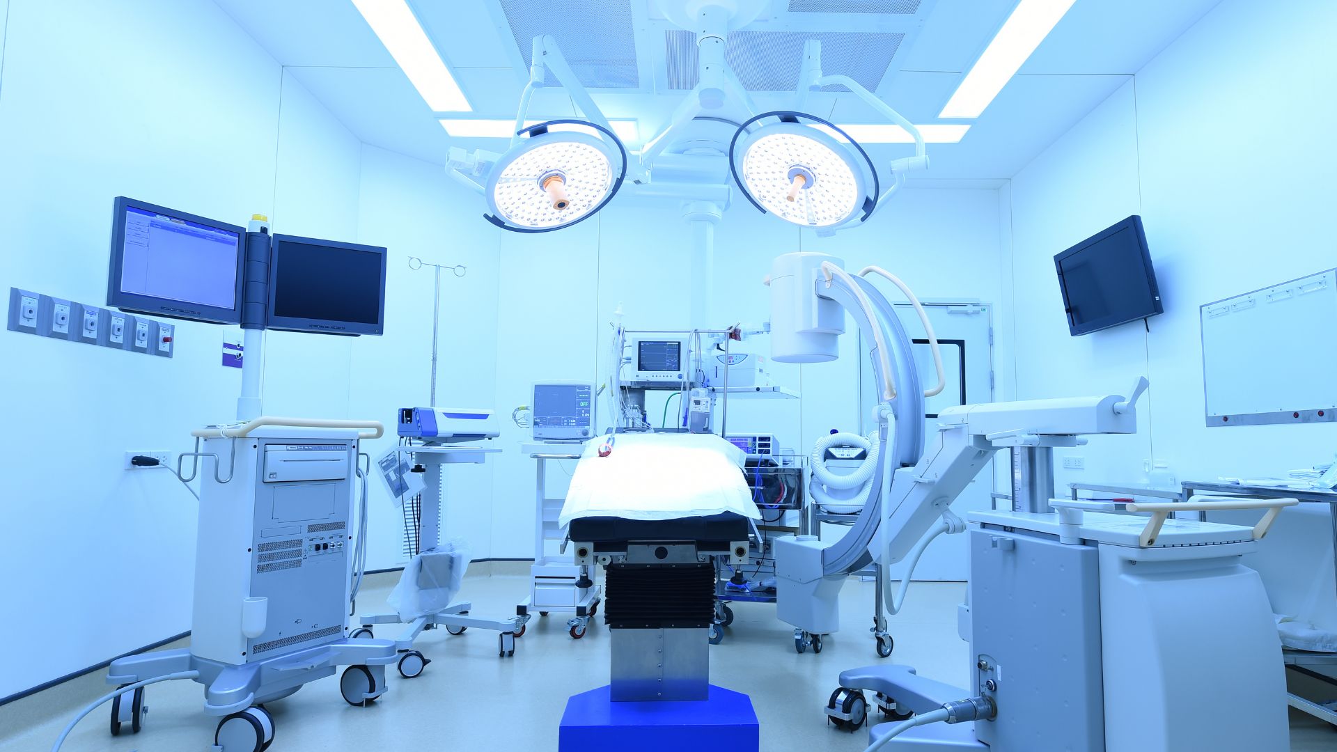 An empty operating room with blue-tinted light.